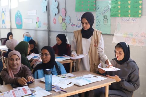 A young woman with girls in a classroom in Gaza