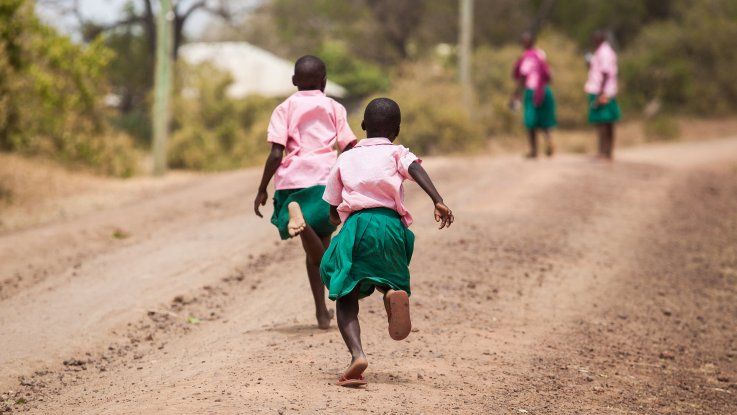 Two girls making their way to school in Kenya. Many girls living in poverty are subject to catcalling and street harassment on their way to and from school